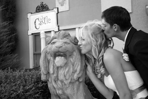Happy couple kissing lion at cavender castle